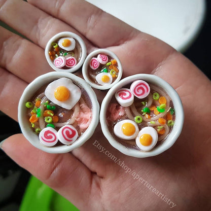 Miniature bowls with food models held in a hand, with Etsy branding visible.