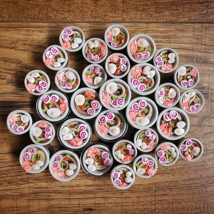 Small round containers with decorative items arranged in a circular pattern on a wooden surface.