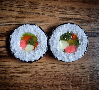 pair of sushi plug earrings with colorful fillings on a wooden surface