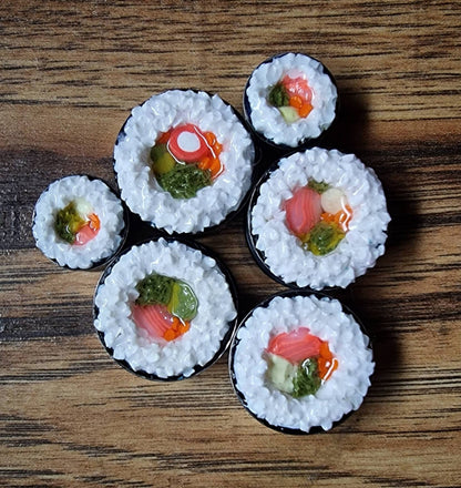 Sushi roll plug earrings with various fillings on a wooden surface