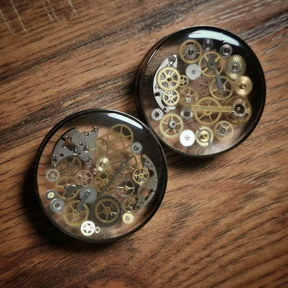 All sizes Steampunk steel tunnel clockwork plug  earring against a wooden floor