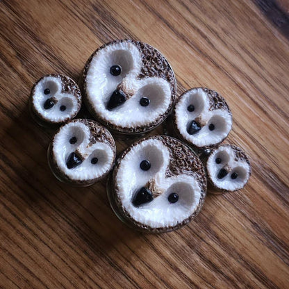 owl plug earrings on a wooden surface
