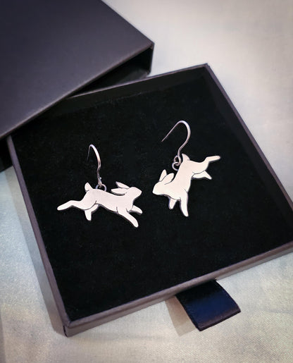 Silver rabbit-shaped earrings on a black jewelry box