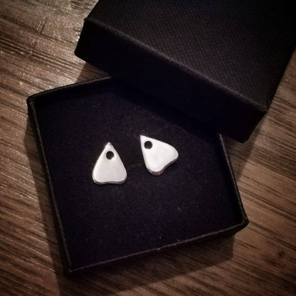 planchette earrings in a black box with a wood background 
